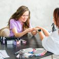 Professional master manicurist at beauty salon. Manicure service, hands treatments, procedures for nails, fingers. Multi-colored nail polish, samples palette, tattoos, cuticle oil, gel uv lamp,gloves.